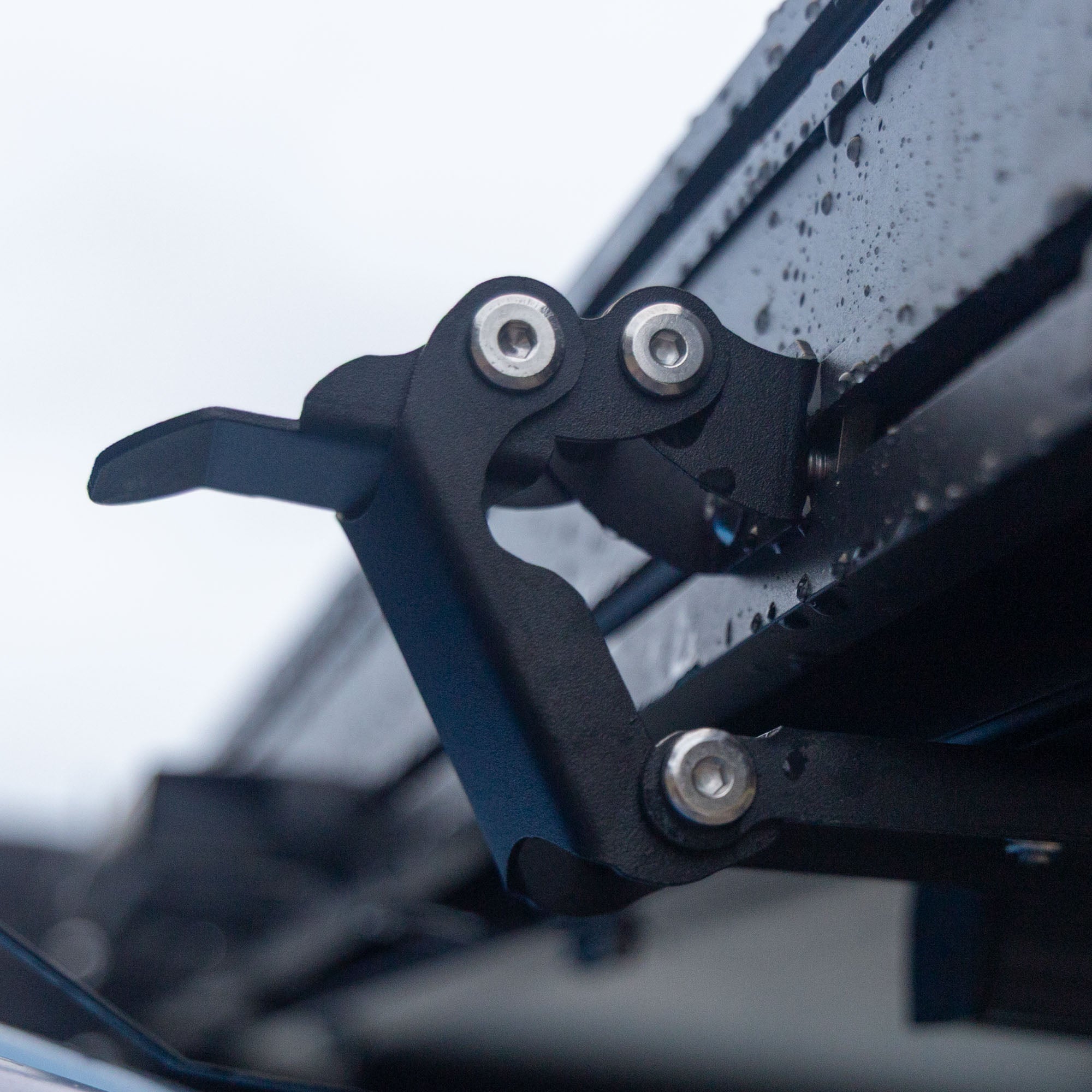 Clamps holding down hardshell rooftop tent