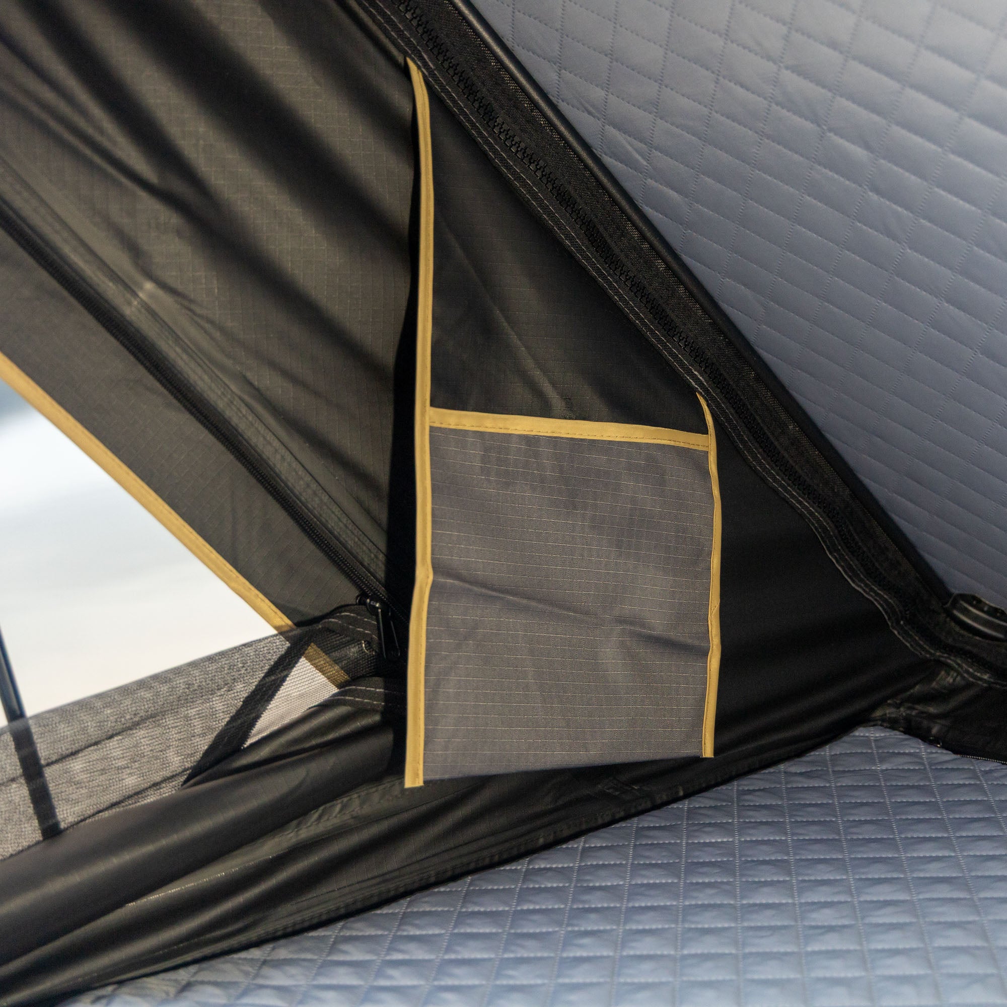 Close-up of a camping tent interior with a pocket and mesh wall.